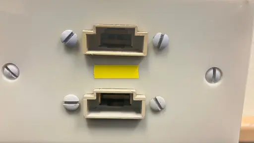 Two vertically adjacent rectangular wall ports with about a ratio of 1 to 4 that are each extended by a smaller rectangular cutout above them in an upside down T fashion.